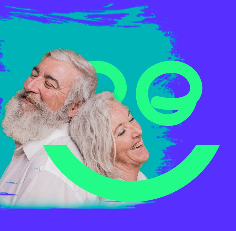 Casal de aposentados sorrindo com o símbolo da Embraemp